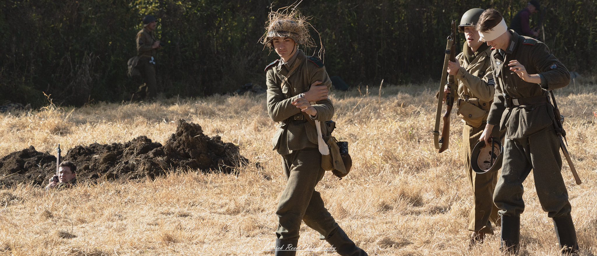 A group of wounded soldiers walks across a battlefield, each bearing visible signs of their injuries. Their uniforms are tattered and stained with mud and blood, reflecting the harsh conditions they've faced. Some soldiers lean on makeshift crutches or support each other for stability as they navigate the uneven terrain. The backdrop features a desolate landscape, with remnants of war scattered across the ground, such as abandoned equipment and debris. Despite their injuries, the soldiers exhibit determination and camaraderie, embodying the resilience of those who have endured the trials of combat.